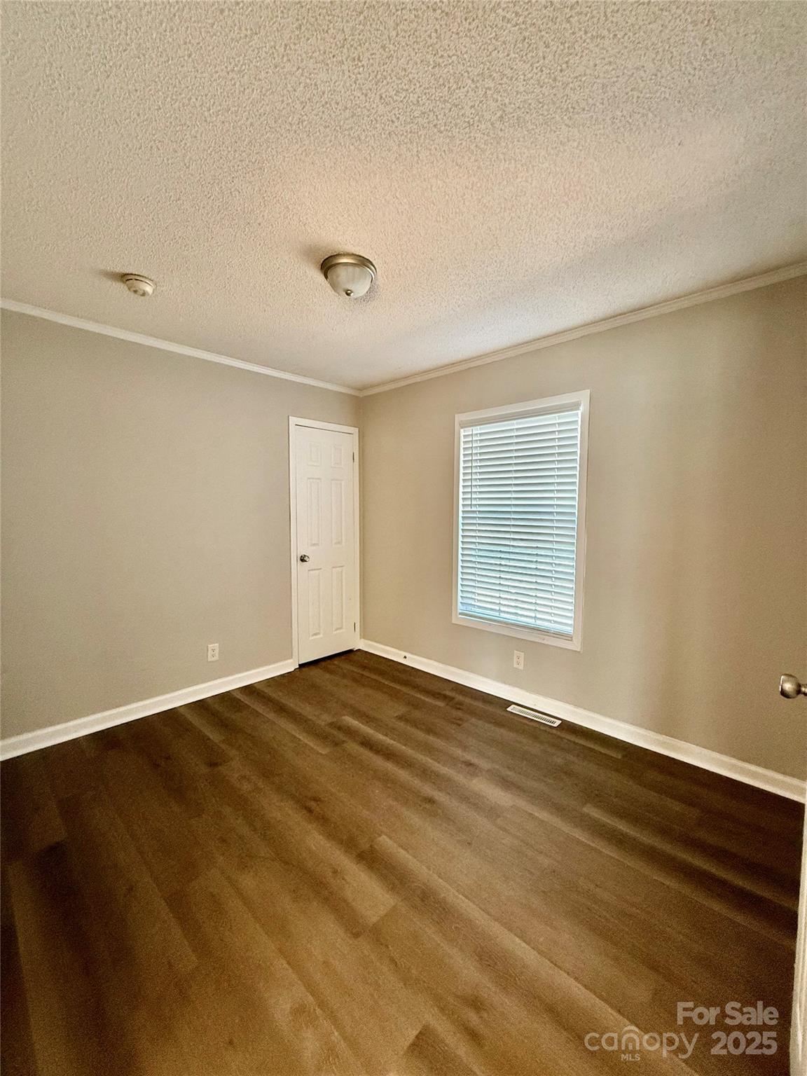 191 Ashford Drive Olin, NC 28660 - Photo 18 of 48 a view of an empty room with wooden floor and a window