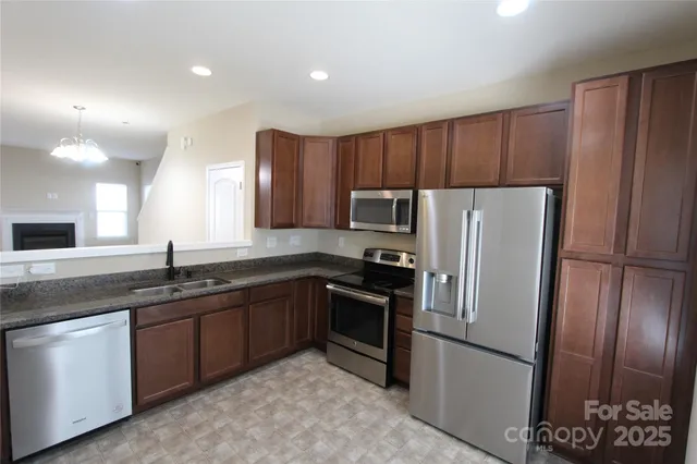 a kitchen with stainless steel appliances granite countertop a refrigerator sink and cabinets