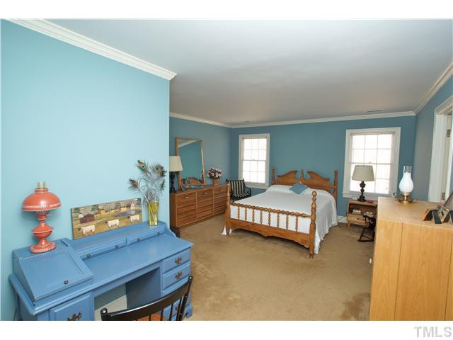7309 Mevan Court Raleigh, NC 27613 - Photo 19 of 22 a bedroom with a bed and a dresser