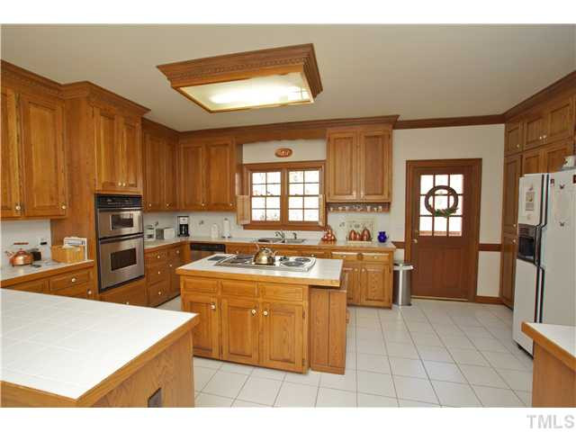 7309 Mevan Court Raleigh, NC 27613 - Photo 5 of 22 a kitchen with a stove a sink a refrigerator and cabinets