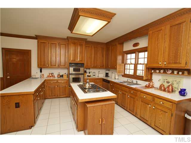 7309 Mevan Court Raleigh, NC 27613 - Photo 6 of 22 a kitchen with stainless steel appliances granite countertop wooden cabinets a stove top oven a sink and dishwasher