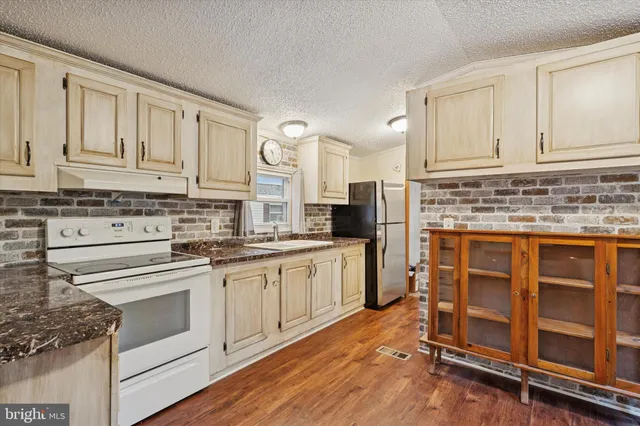 a kitchen with granite countertop white cabinets and white appliances