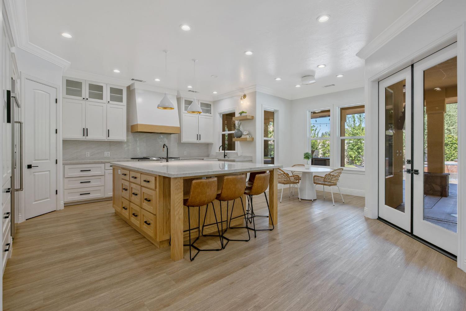 1548 North Rova Street Visalia, CA 93291 - Photo 4 of 9 a kitchen with stainless steel appliances kitchen island granite countertop a stove a sink a refrigerator and white cabinets with wooden floor