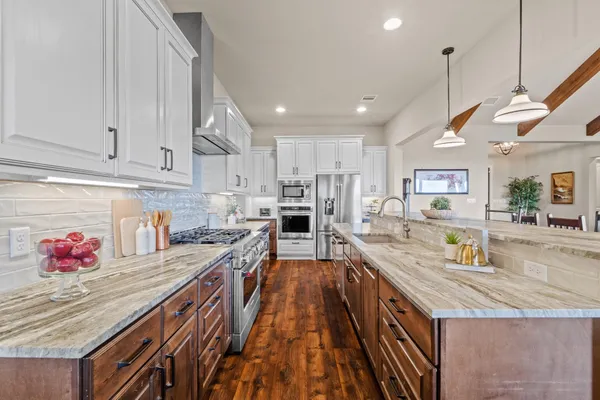 a kitchen with stainless steel appliances granite countertop wooden cabinets and granite counter tops