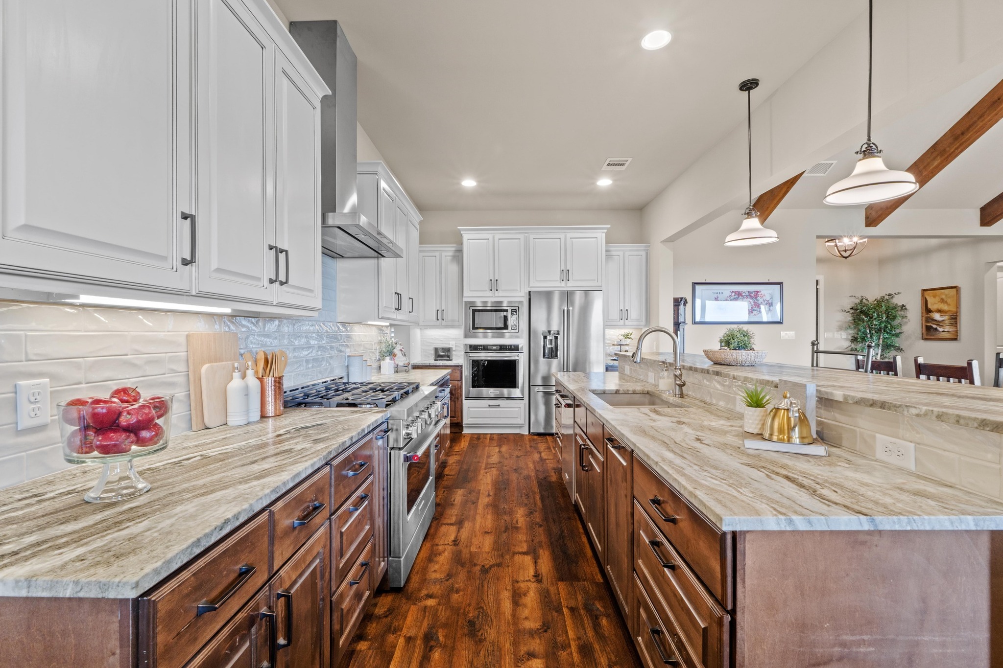 18817 Hidden Ridge Place Jonestown, TX 78645 - Photo 13 of 40 Kitchen with dark wood finished floors, a sink, wall chimney exhaust hood, high quality appliances, and white cabinetry