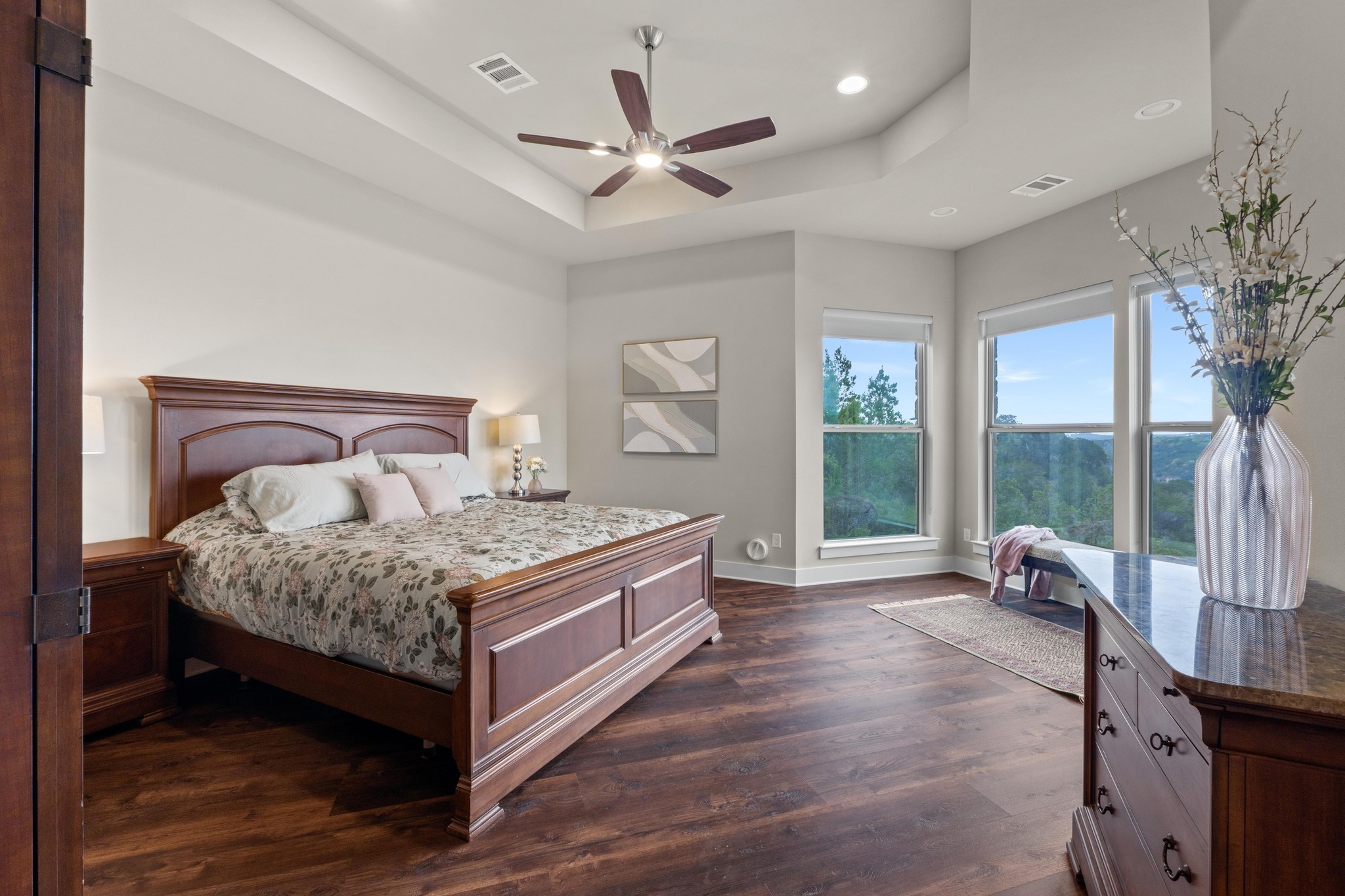 18817 Hidden Ridge Place Jonestown, TX 78645 - Photo 16 of 40 Bedroom featuring dark wood-style floors, baseboards, a tray ceiling, and visible vents