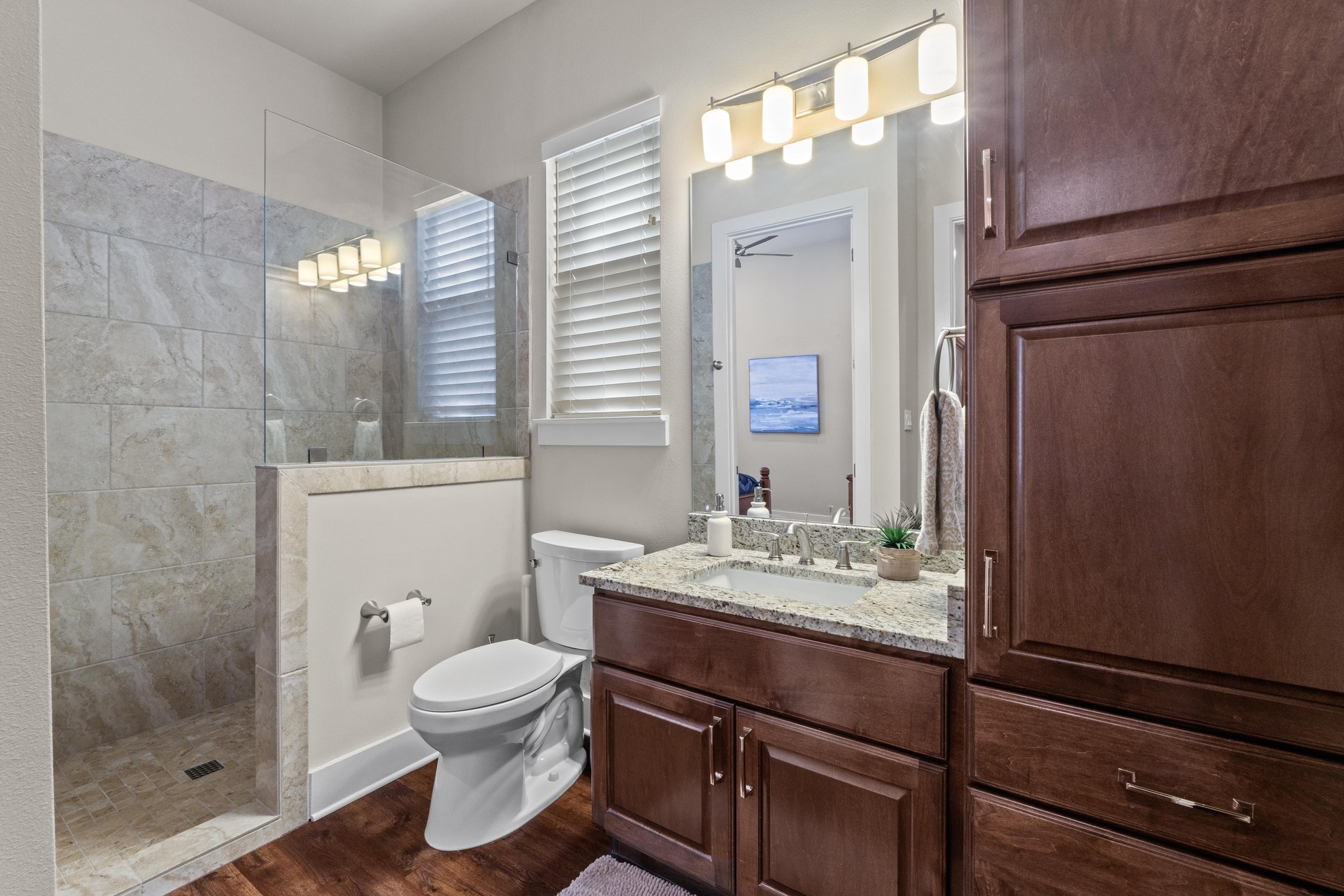 18817 Hidden Ridge Place Jonestown, TX 78645 - Photo 21 of 40 a bathroom with a granite countertop sink toilet a mirror and shower