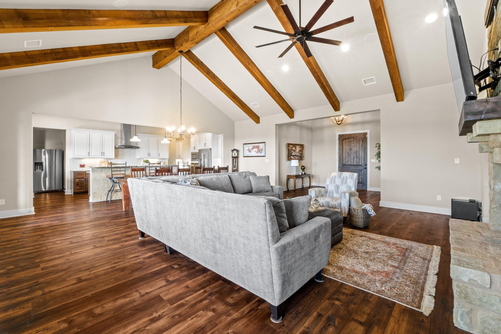 18817 Hidden Ridge Place Jonestown, TX 78645 - Photo 9 of 40 Living area featuring high vaulted ceiling, ceiling fan with notable chandelier, dark wood finished floors, baseboards, and beam ceiling