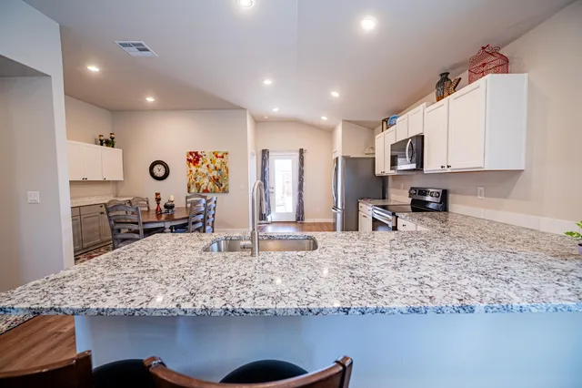 a kitchen with kitchen island granite countertop a counter top space appliances and cabinets