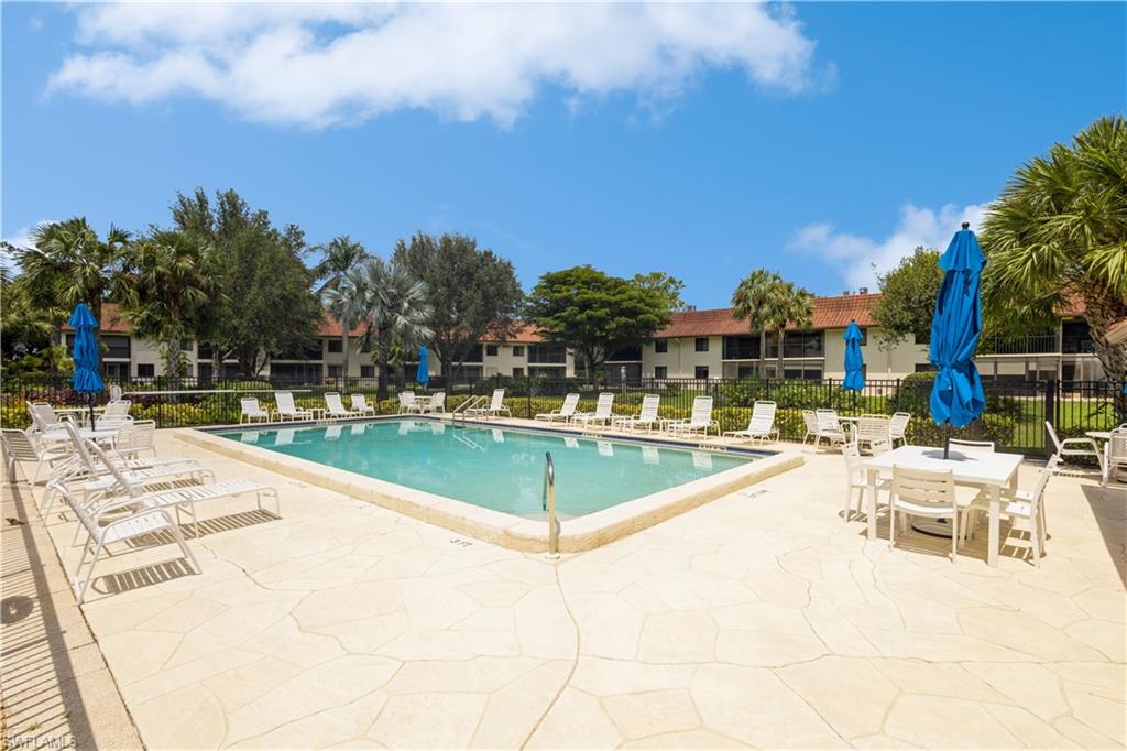 4963 Pepper Circle, Unit D202 Naples, FL 34113 - Photo 17 of 17 a view of a swimming pool with a lawn chairs