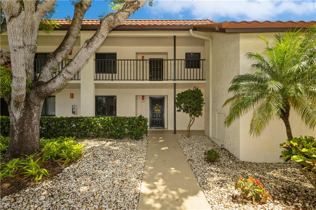 4963 Pepper Circle, Unit D202 Naples, FL 34113 - Photo 2 of 17 a front view of a house with a garden