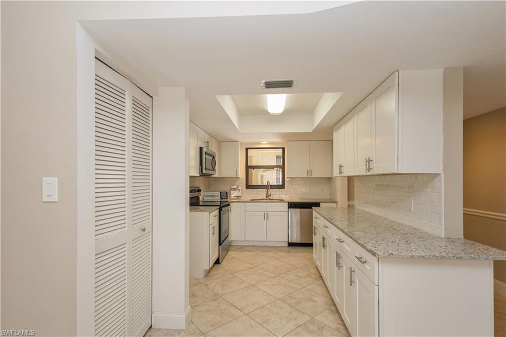 4963 Pepper Circle, Unit D202 Naples, FL 34113 - Photo 5 of 17 a kitchen with sink and cabinets
