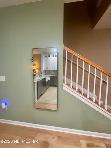 a view of a living room with kitchen and wooden floor