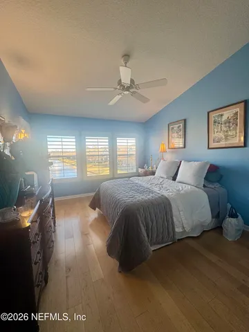 a spacious bedroom with a bed and a chandelier