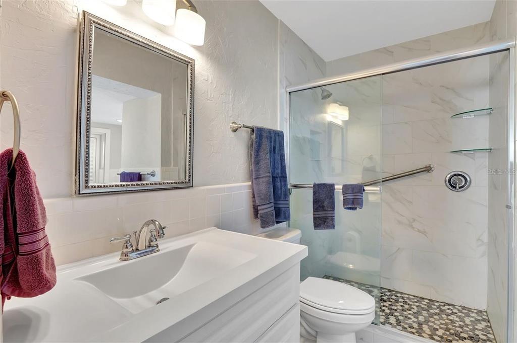 250 Bangsberg Road Southeast Port Charlotte, FL 33952 - Photo 20 of 59 a bathroom with a sink toilet a mirror and shower