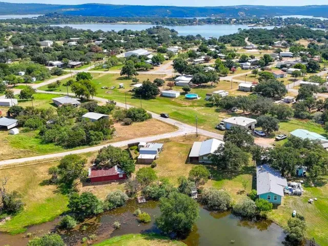 an aerial view of residential houses with outdoor space and lake view