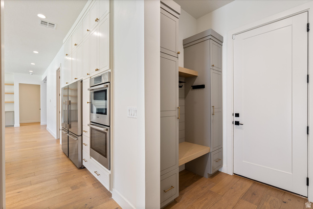 1192 East Corral Way Washington, UT 84780 - Photo 35 of 81 Hallway featuring wood-finish flooring, recessed lighting, and built-in white cabinetry with gold-finish hardware