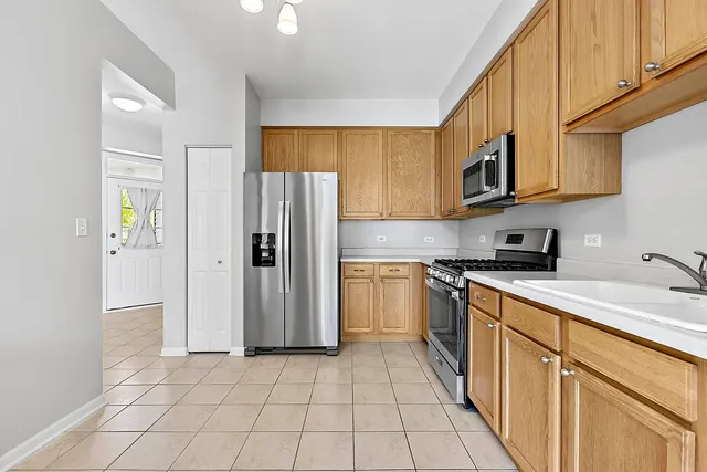 a kitchen with stainless steel appliances granite countertop a refrigerator and a stove top oven