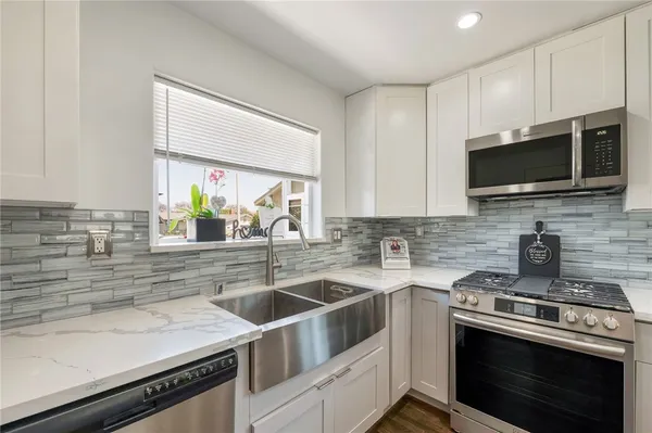 a kitchen with stainless steel appliances a sink a stove and microwave
