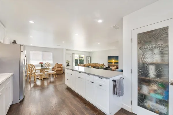 a large kitchen with a lot of counter space and wooden floor