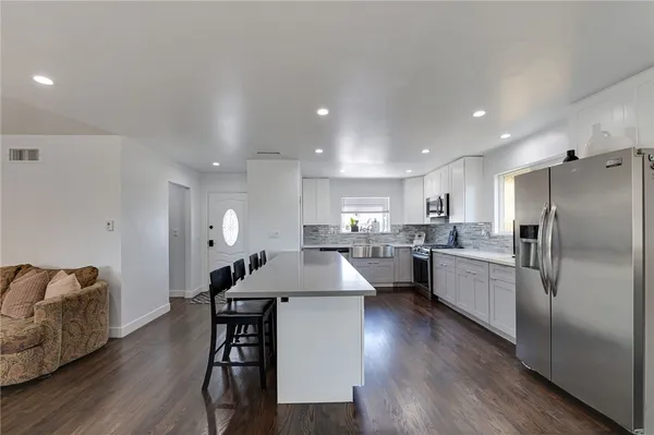 a large kitchen with a table and stainless steel appliances