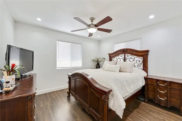 a bedroom with a bed and a flat tv screen on dresser