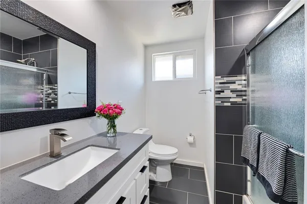 a bathroom with a sink a toilet and mirror