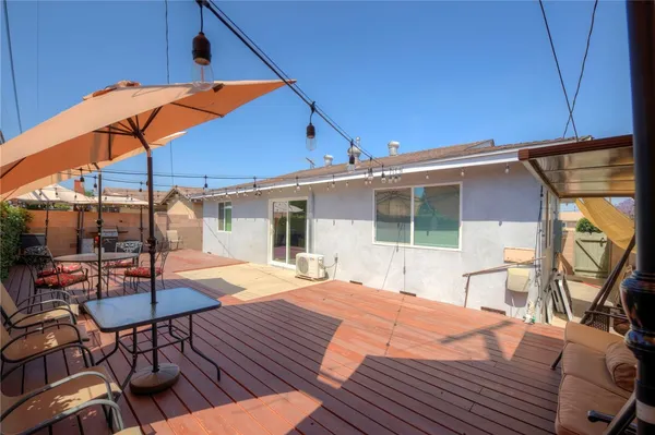 a patio with a table and chairs under an umbrella