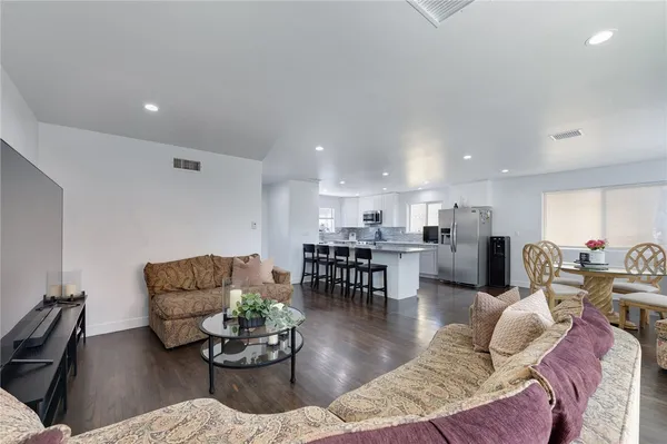 a living room with furniture kitchen view and a dining table
