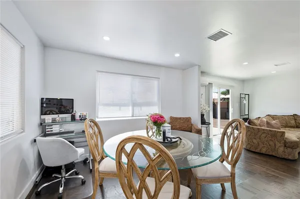 a view of a a dining room with furniture window and wooden floor