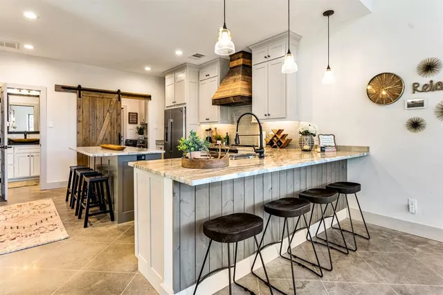 a kitchen with stainless steel appliances granite countertop a sink a stove and a refrigerator