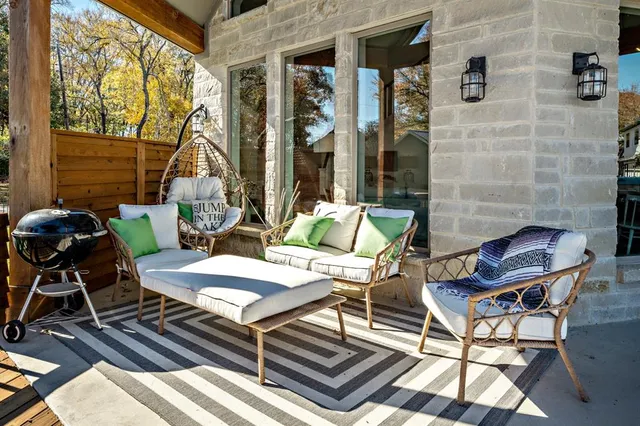 a view of a patio with a dining table and chairs with wooden floor