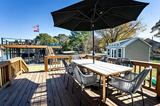 a view of deck with table and chairs under an umbrella with wooden floor