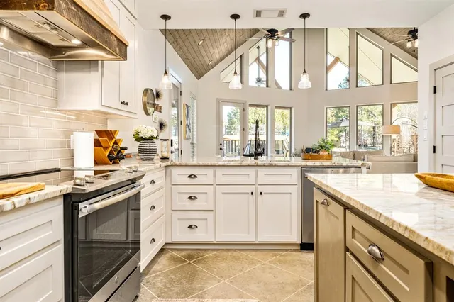 a kitchen with stainless steel appliances granite countertop a stove and cabinets