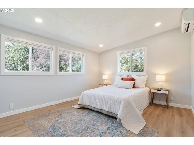 a bedroom with a large bed and wooden floor