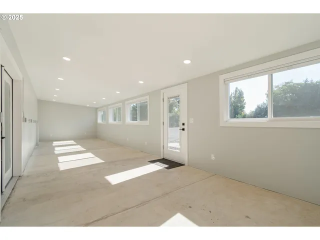 a view of empty room with wooden floor and window