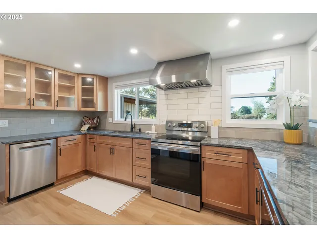 a kitchen with stainless steel appliances granite countertop a sink stove and cabinets