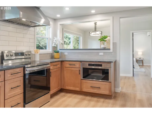 a kitchen with stainless steel appliances a stove a sink and a microwave