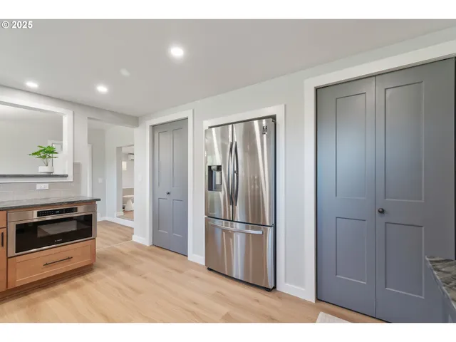 a view of kitchen with refrigerator and window
