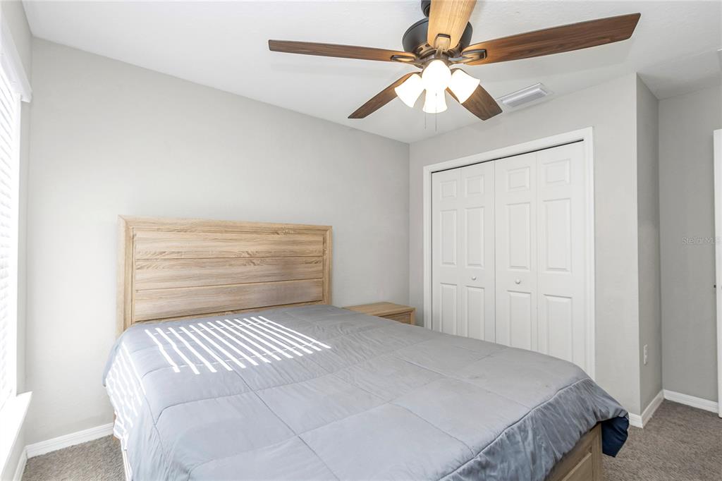 Undisclosed Address Ocala, FL 34480 - Photo 17 of 38 a bedroom with a large bed and a ceiling fan