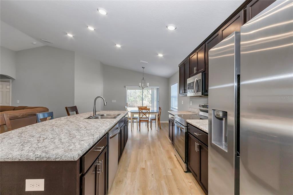 Undisclosed Address Ocala, FL 34480 - Photo 33 of 38 a kitchen with stainless steel appliances granite countertop a kitchen island a stove and a refrigerator