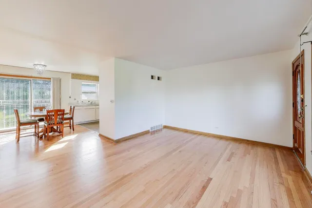 an empty room with wooden floor and a window