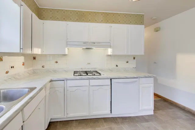 a kitchen with cabinets appliances a sink and a counter space