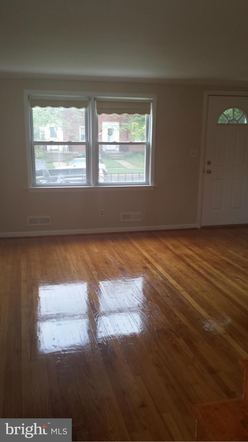 1560 Clairidge Road Baltimore, MD 21207 - Photo 14 of 16 a view of an empty room with wooden floor and a window