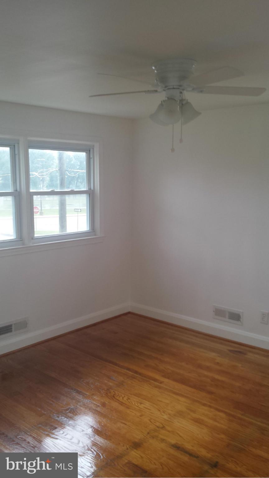 1560 Clairidge Road Baltimore, MD 21207 - Photo 15 of 16 a view of an empty room with wooden floor and a window