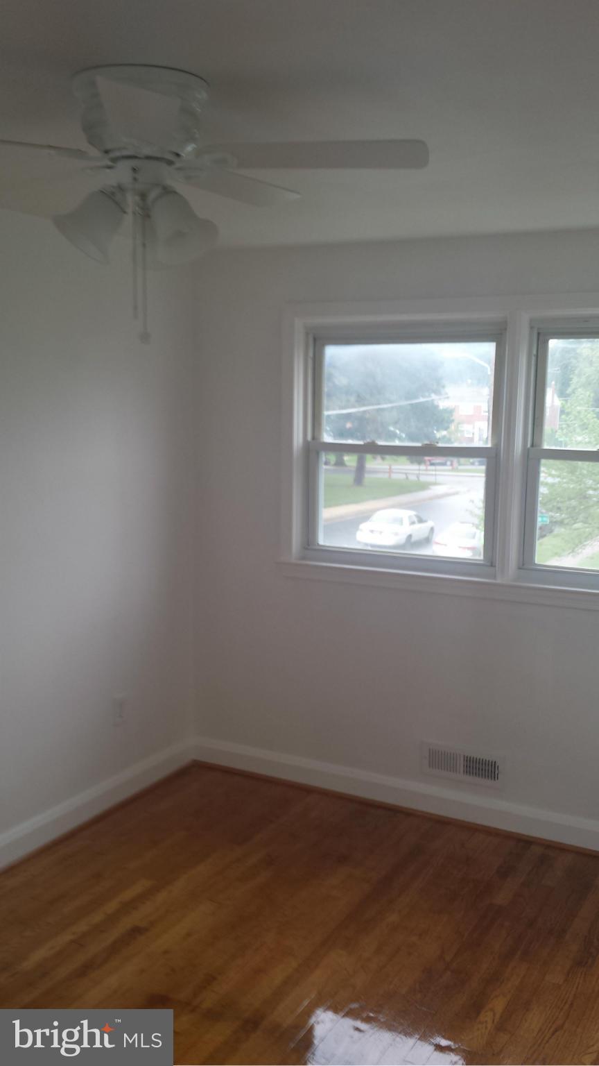 1560 Clairidge Road Baltimore, MD 21207 - Photo 16 of 16 an empty room with wooden floor and windows