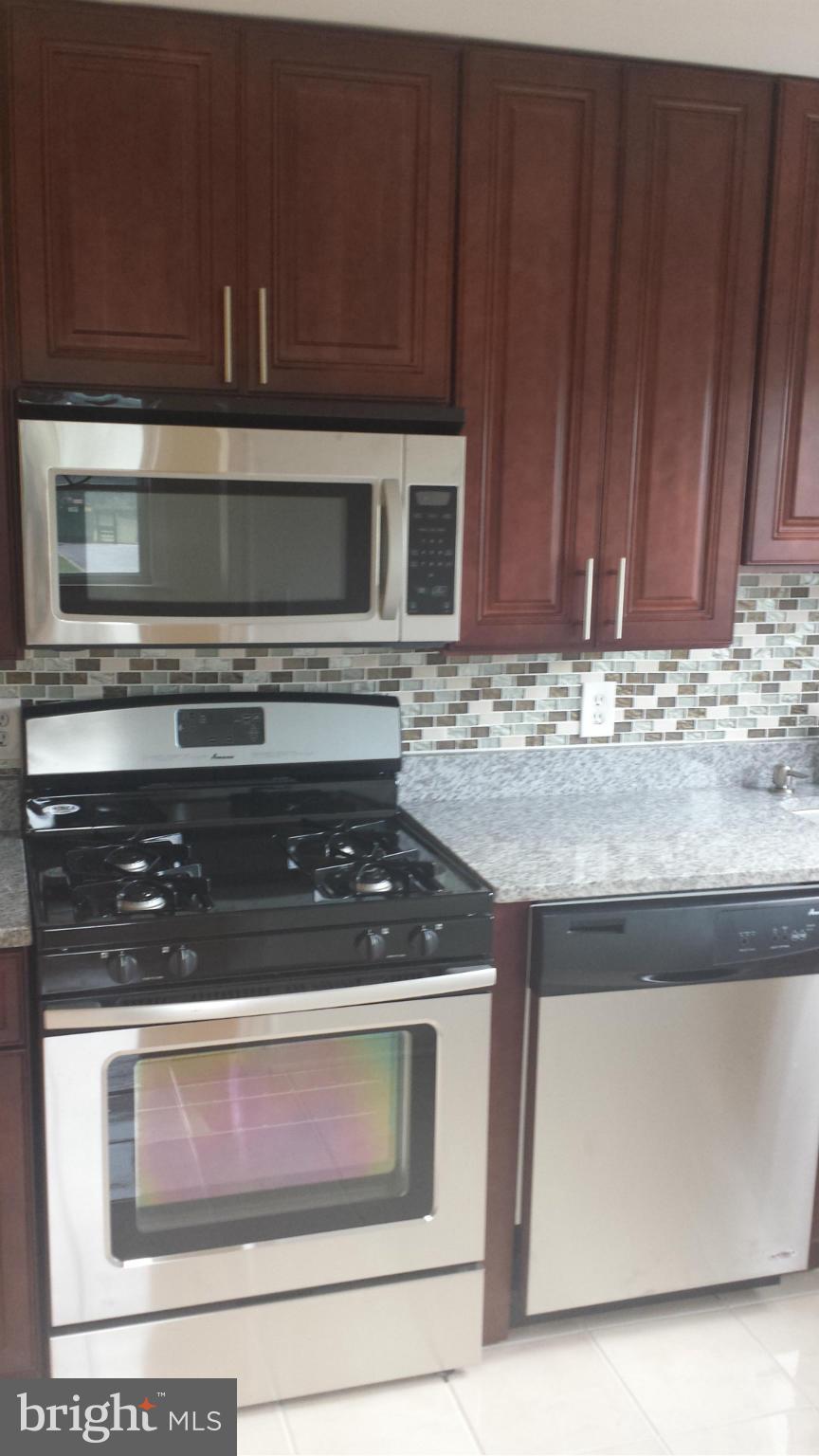 1560 Clairidge Road Baltimore, MD 21207 - Photo 8 of 16 a kitchen with granite countertop a stove and a microwave oven