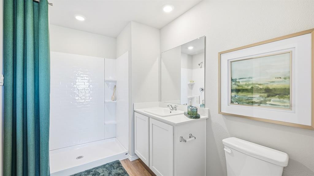 5424 Corduroy Road Krum, TX 76249 - Photo 17 of 38 a bathroom with a sink a toilet a large mirror and shower