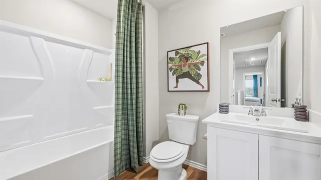 a bedroom with a bed and dresser with mirror