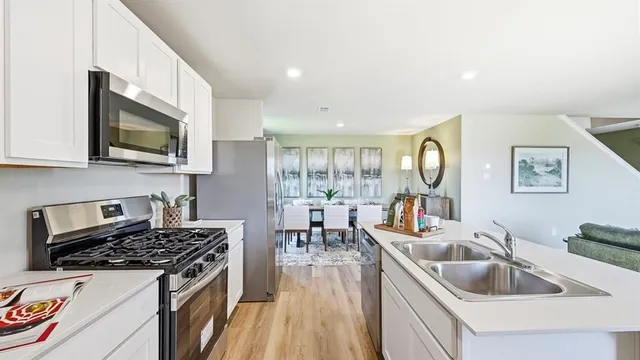 a kitchen that has a lot of cabinets a sink and appliances